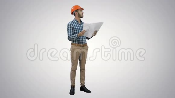 年轻工程师在头盔检查施工图纸的白色背景视频的预览图