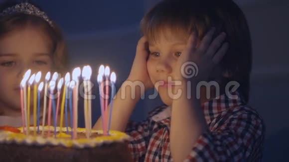 微笑的男孩在你慢动作地吹灭生日蛋糕上的蜡烛之前许了个愿视频的预览图