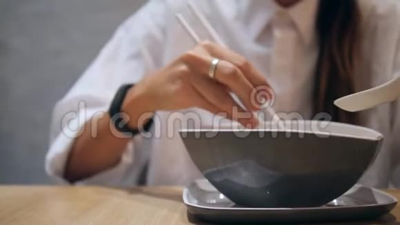 亚洲旅游女孩在餐厅用筷子吃传统的汤汤4K视频的预览图