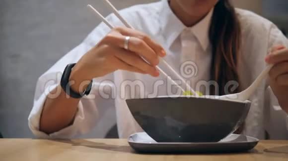 亚洲旅游女孩在餐厅用筷子吃传统的汤汤4K视频的预览图