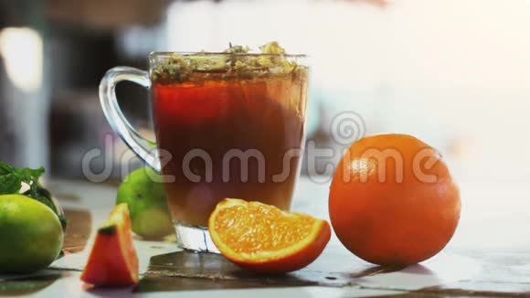 一杯冰茶菊花和橘子黑木桌上的冰块视频的预览图