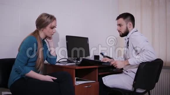 医生在医院办公室的办公桌上和病人说话视频的预览图