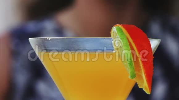 靠近一个女人享受一种热带鸡尾酒上面装饰着新鲜水果视频的预览图