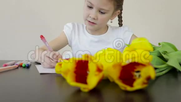 快乐的小女孩在桌子上为他妈妈做了一张节日卡片视频的预览图