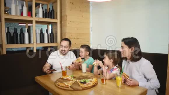 幸福家庭之父在咖啡馆里用披萨做自拍视频的预览图