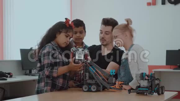混合种族群体的学校儿童控制机器人机器与远程控制老师有创意的孩子视频的预览图
