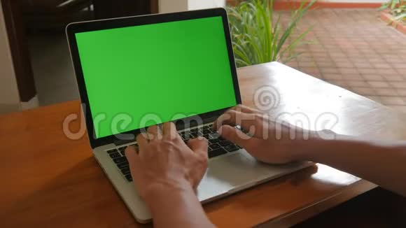 男人在家里用笔记本电脑和绿色屏幕自由职业者在家工作视频的预览图