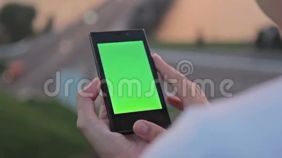 在街上看手机的女人绿色的屏幕视频的预览图