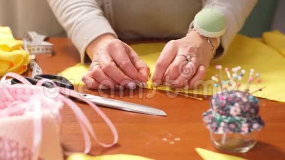 一位年轻女裁缝的手根据裁缝的传统缝制一件布裁缝用得很好视频的预览图