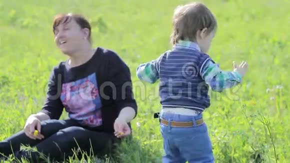 小男孩在公园里和他妈妈玩视频的预览图