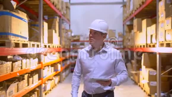 员工男仓库工人工程师戴安全帽在施工现场仓库工作在物流中行走视频的预览图