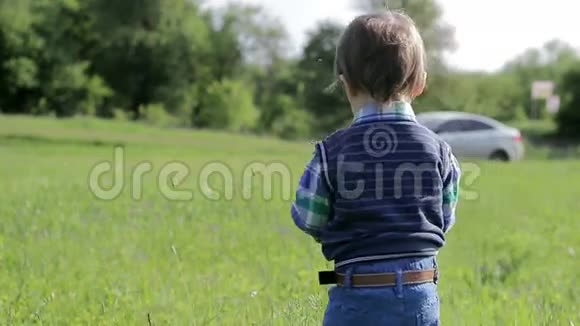 小男孩带着电话走在大自然中视频的预览图