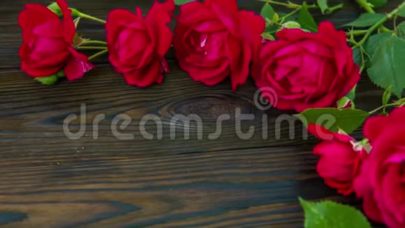 木桌上有红色玫瑰的浪漫背景俯视视频的预览图