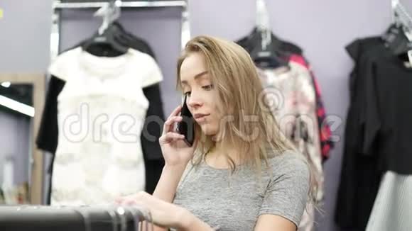 漂亮女孩在一家服装店打电话视频的预览图