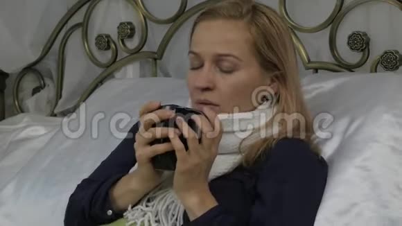 生病的女人躺在家里的床上喝着蜂蜜热饮料4K视频的预览图