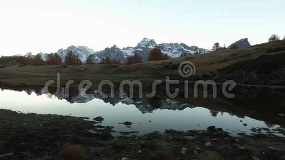 侧面POV步行在秋天的田野小路附近的湖与雪骑傍晚的秋日在五彩缤纷的红林中徒步旅行视频的预览图