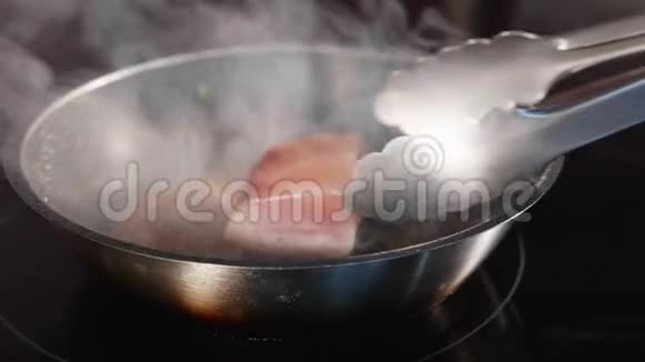 锅炸鱼吞拿鱼片在热气腾腾的煎锅上慢动作视频的预览图