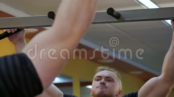 强壮的男子运动员在健身房做下巴练习视频的预览图