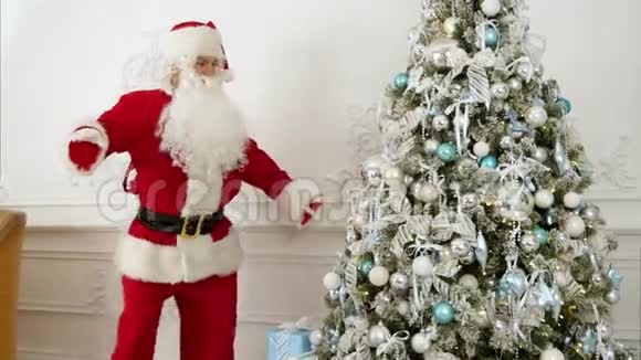 圣诞老人在圣诞树旁边跳有趣的机器人舞视频的预览图