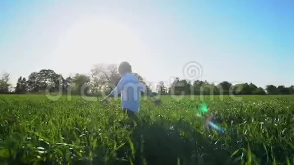 一个小男孩跑过田野斯坦迪卡姆起飞了慢动作视频的预览图
