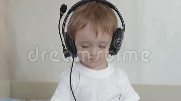 带着耳机的小男孩摇摇头挥动手臂视频的预览图