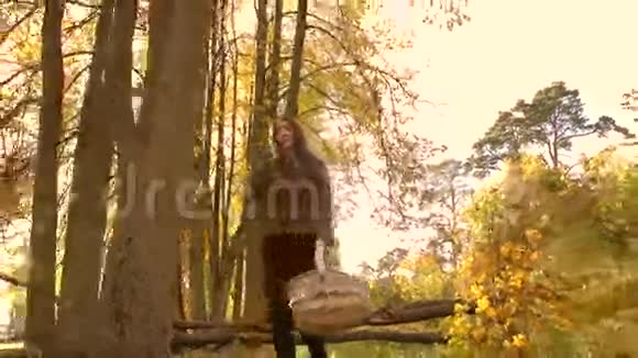 布鲁内特女孩走在秋天的森林里拿着一个篮子4K型安定片视频的预览图