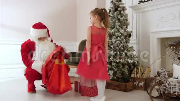 圣诞老人送礼物给漂亮的小女孩拥抱她视频的预览图