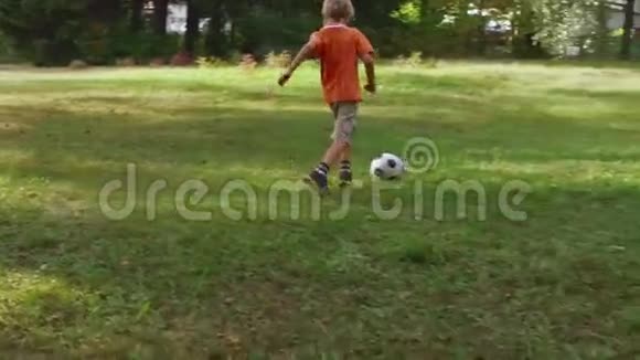 男孩在城市公园踢足球视频的预览图
