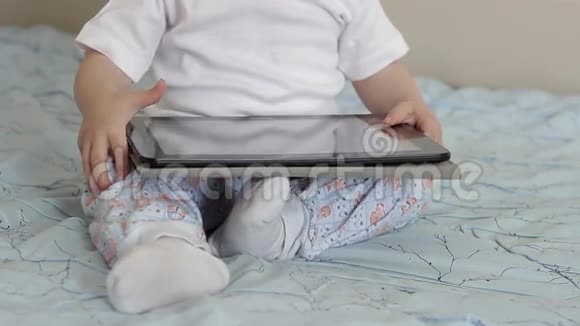 小孩的手在平板电脑屏幕上移动视频的预览图