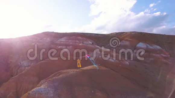 空中一个年轻的女孩站在红山在高山上放风筝自由的思想视频的预览图