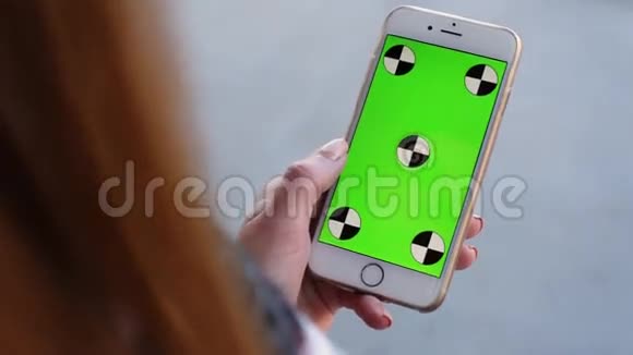 智能手机由女性手握绿色屏幕Chroma键快关门跟踪运动垂直的白色背景6视频的预览图