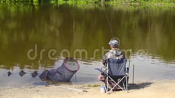 渔夫正在河的岸边钓鱼湖的水面上钓鱼视频的预览图