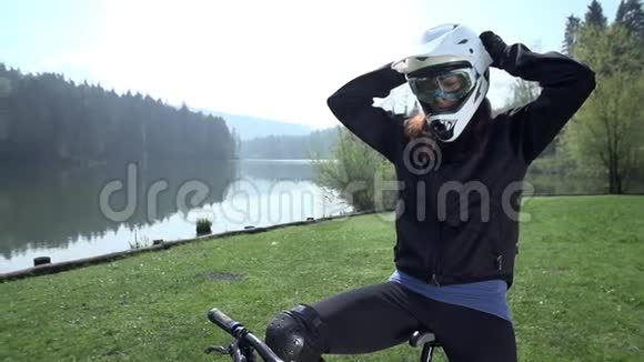 专业的下坡自行车手在湖边起飞视频的预览图