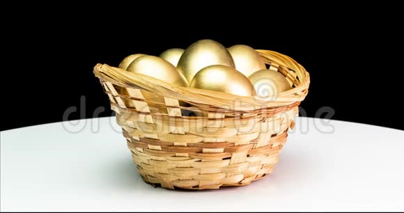 黑色背景下篮子里的金蛋金蛋特写复活节春天投资和退休概念视频的预览图