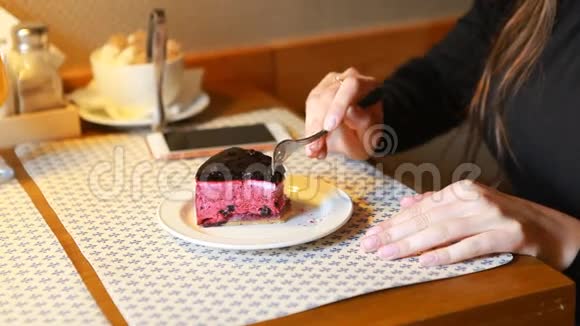 那个女孩在咖啡馆里吃蓝莓芝士甜点室内视频的预览图