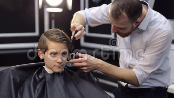 男理发师在理发店剪一个小男孩视频的预览图
