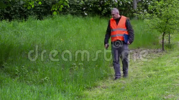 园林经理在智能手机上拍照靠近劣质割草机视频的预览图