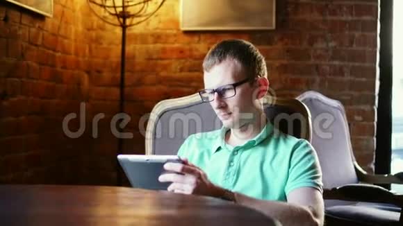 那个人坐在咖啡馆的一张小桌子旁那个人在桌面上玩一个垫子那个人看着一个小玩意咖啡厅视频的预览图