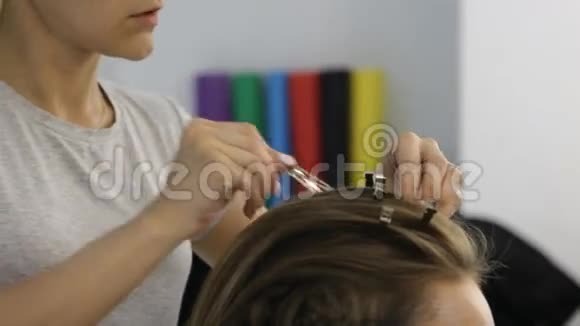 美容师里的女人美容师的手在客户的头发上工作特写视频的预览图