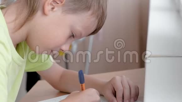 学校的孩子学着坐在桌子旁写信做作业视频的预览图
