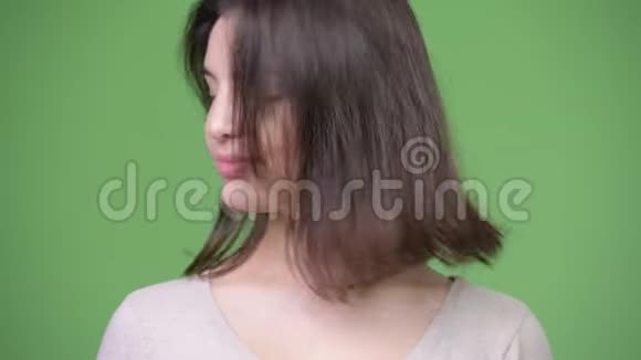 年轻漂亮的女人在绿色的背景下点头视频的预览图