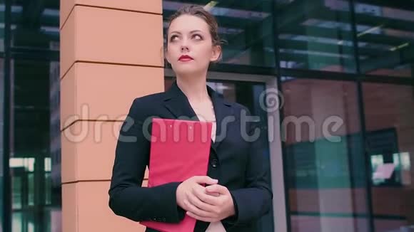 有魅力的年轻商务女性正在等待会议穿着商务服的女孩手里拿着红色的文件夹视频的预览图