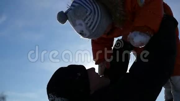 男人在阳光明媚的冬天和你的孩子玩抱在怀里冬季景观视频的预览图