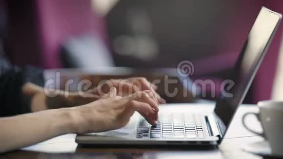 使用笔记本电脑拍摄的女性作物女性坐在咖啡馆里在笔记本电脑上打字视频的预览图