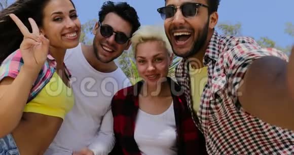 人群在手机上自助拍照快乐微笑男女混合视频的预览图