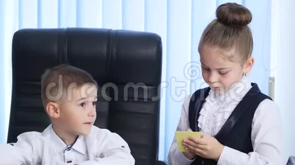 小老板和秘书活泼开朗的小男孩发号施令穿着正式服装的小女孩站在他身边视频的预览图
