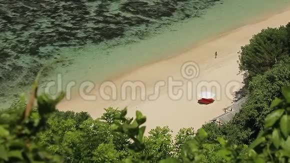 穿着白色连衣裙沙滩遮阳伞热带海滨日光浴的瘦女人视频的预览图