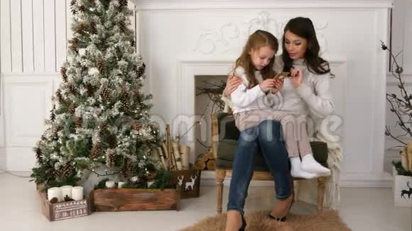 妈妈教她的小女儿如何打电话给圣诞老人视频的预览图
