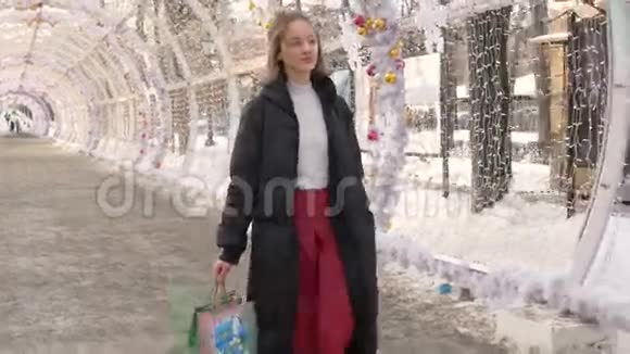 年轻漂亮的女孩走过城市的街道视频的预览图