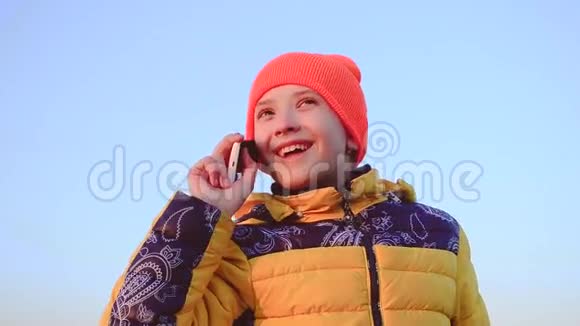 少女在蓝天背景上打电话视频的预览图